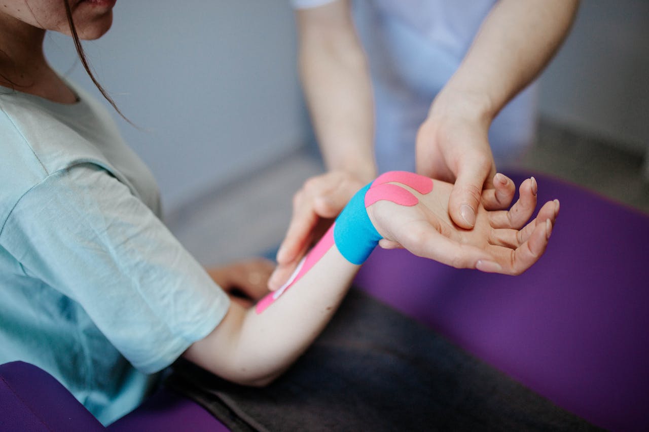 why-choose-us Close-up of a therapist applying kinesio tape for pain relief during a therapy session.